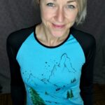 A loose-fitting black T-shirt with long, fitted sleeves, featuring an illustration of a Rainbow Poppy.